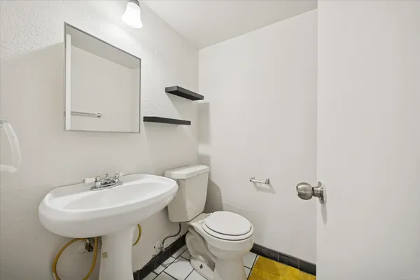 a bathroom with a sink a toilet and mirror