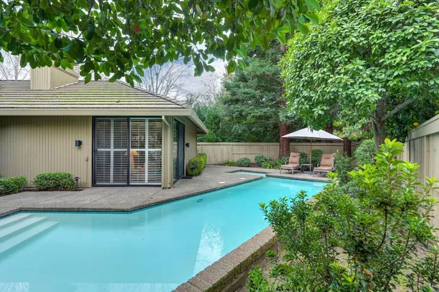 an aerial view of residential houses with outdoor space and trees