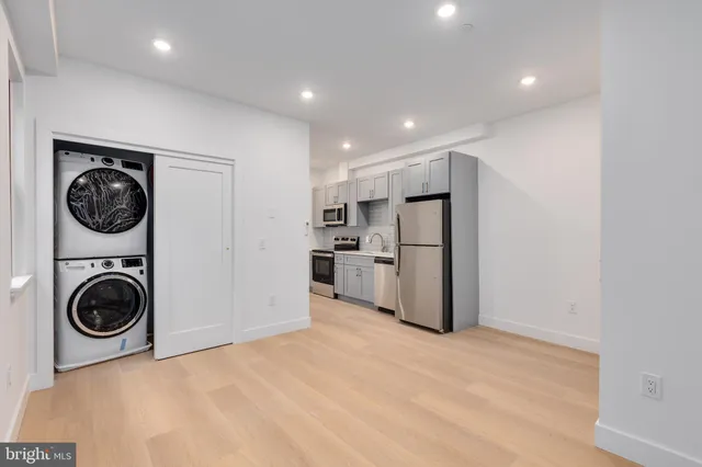 a view of a kitchen with a sink refrigerator and washer