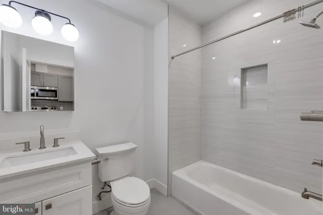 a bathroom with a toilet a sink a mirror and vanity