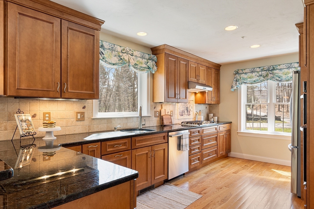 1148 Hill Road, Unit 1148 Boxborough, MA 01719 - Photo 5 of 31 a kitchen with stainless steel appliances granite countertop wooden cabinets a sink dishwasher a stove and a refrigerator with wooden floor