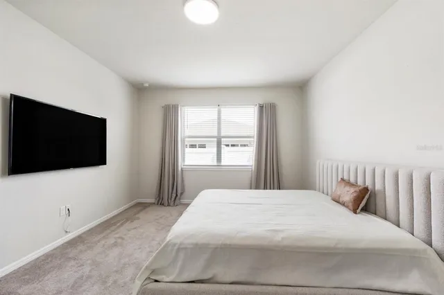 a bedroom with a bed and a flat screen tv