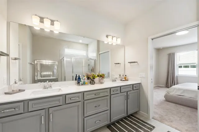 a bathroom with double vanity sinks a vanity a mirror and a vanity