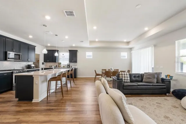 a living room with lots of furniture and kitchen view