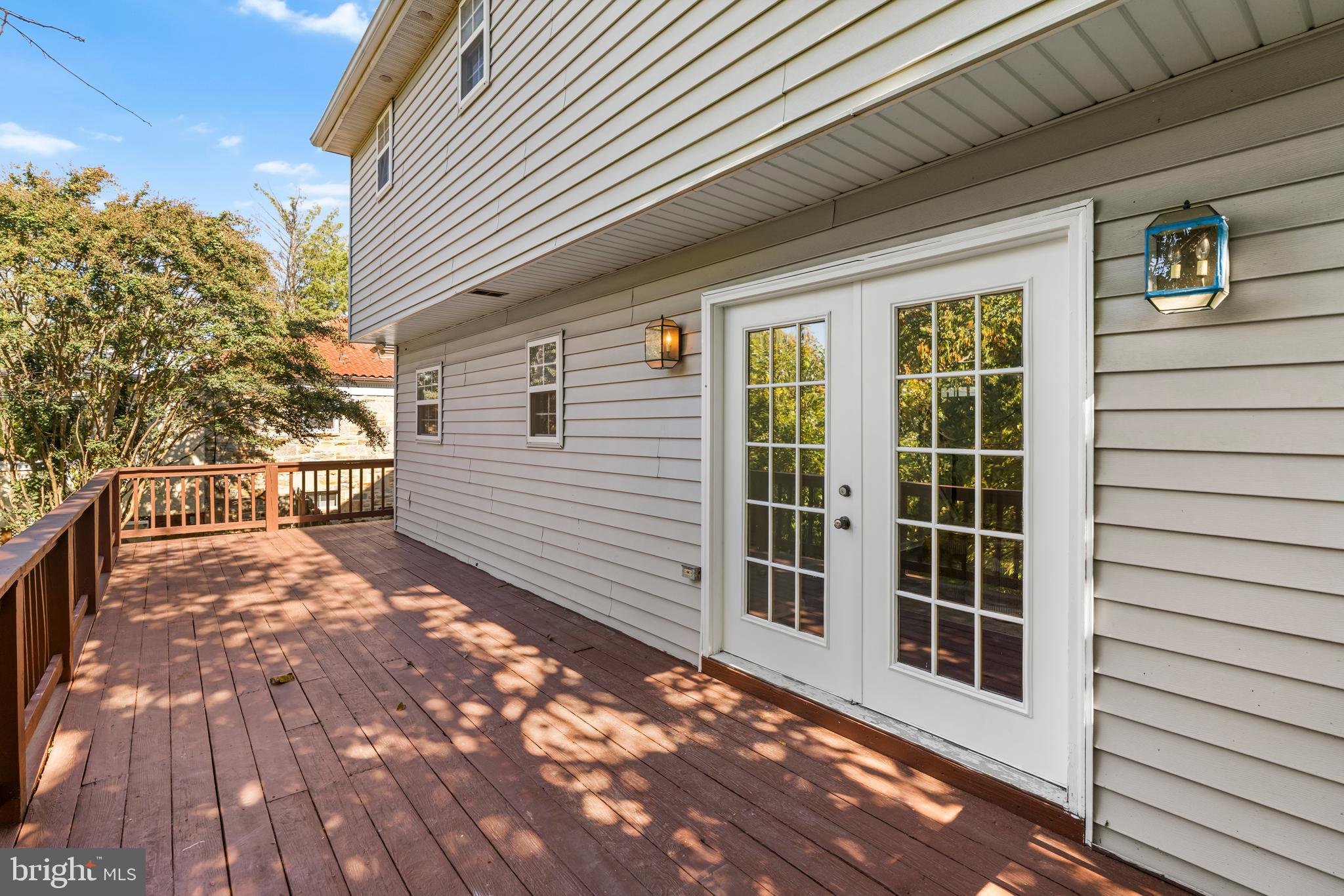6416 Sherwood Road Baltimore, MD 21239 - Photo 26 of 29 a view of a balcony with wooden floor and fence and a floor to ceiling window