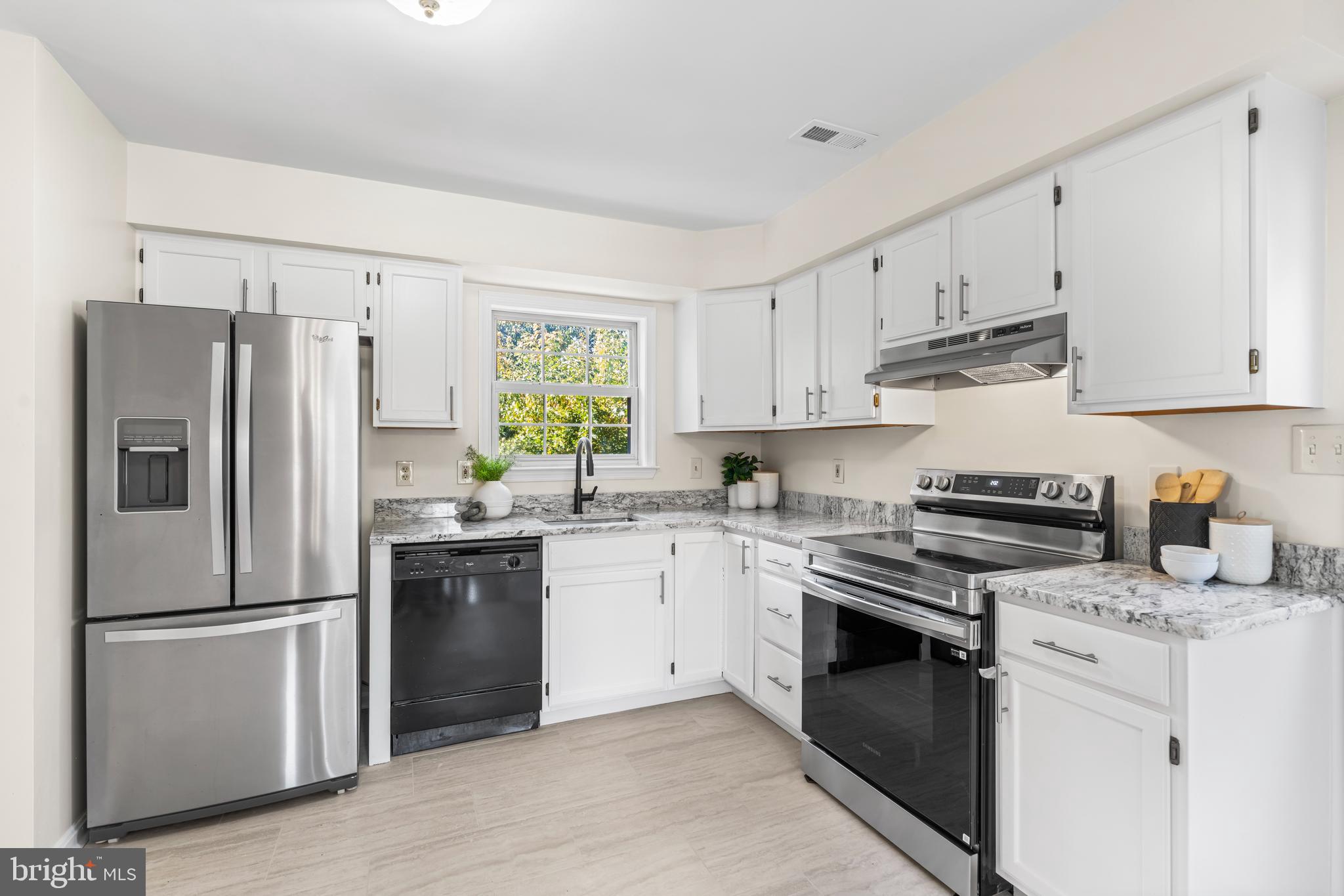 6416 Sherwood Road Baltimore, MD 21239 - Photo 6 of 29 a kitchen with cabinets stainless steel appliances and window