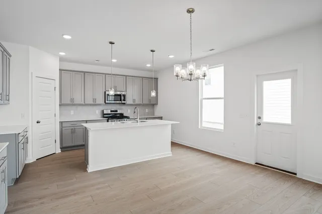 a kitchen with kitchen island white cabinets stainless steel appliances and window