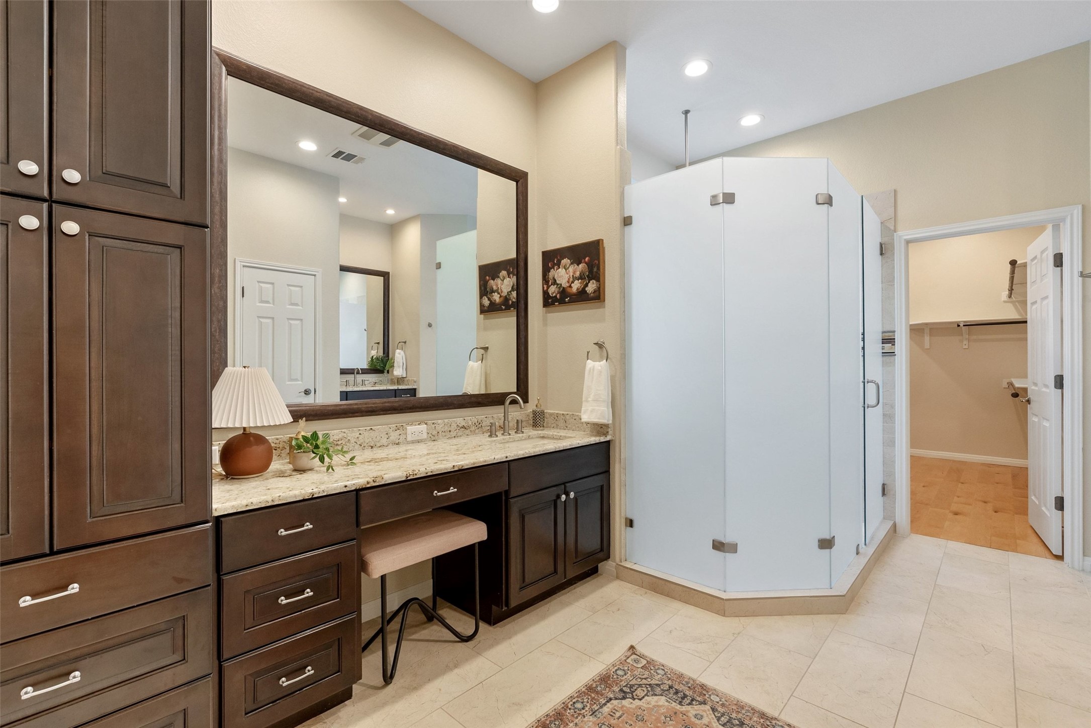 8215 Dark Ridge Cove Austin, TX 78737 - Photo 19 of 40 The large primary en suite bathroom features two separate granite counter vanities, updated cabinetry, a frameless glass walk-in shower, and huge walk-in closet.