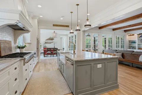 a kitchen with stainless steel appliances granite countertop a sink window and cabinets