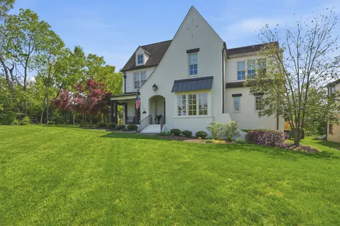 a view of a big house with a big yard and potted plants