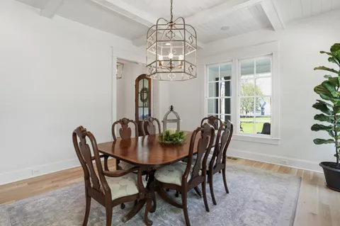 a bedroom with a bed a mirror on the dresser and next to a window
