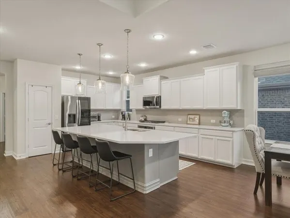 a large kitchen with a table and chairs in it
