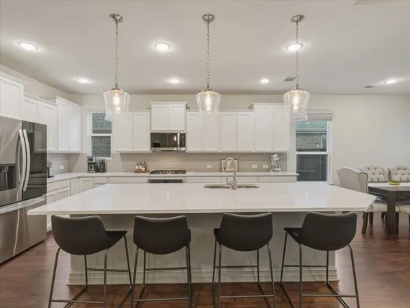 a kitchen with a sink and chairs