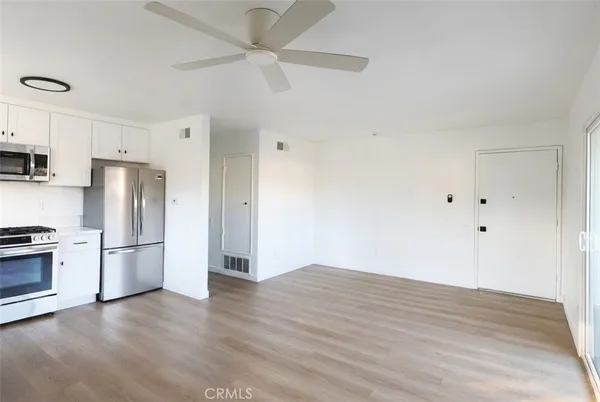 a view of kitchen with stainless steel appliances a refrigerator and a stove top oven