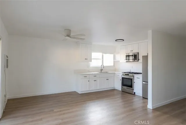 a view of a kitchen with a sink dishwasher and wooden floor
