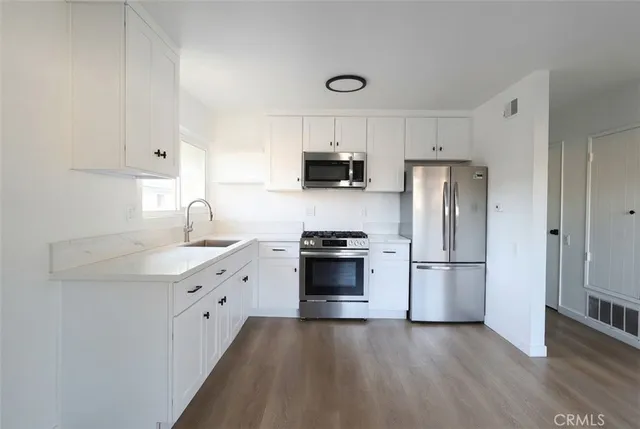 a kitchen with stainless steel appliances a refrigerator stove and sink