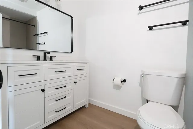 a bathroom with a toilet sink vanity and mirror