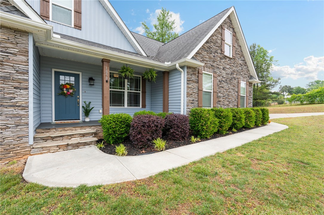 1050 Old Dacusville Road Easley, SC 29640 - Photo 4 of 33 This charming home features a welcoming entrance with stacked stone accents and well-maintained landscaping.