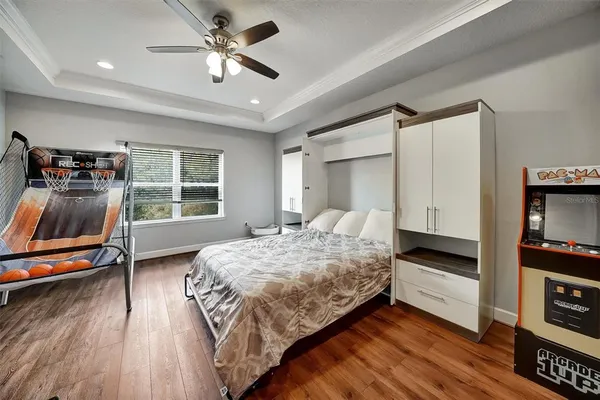 a spacious bedroom with a bed and a ceiling fan