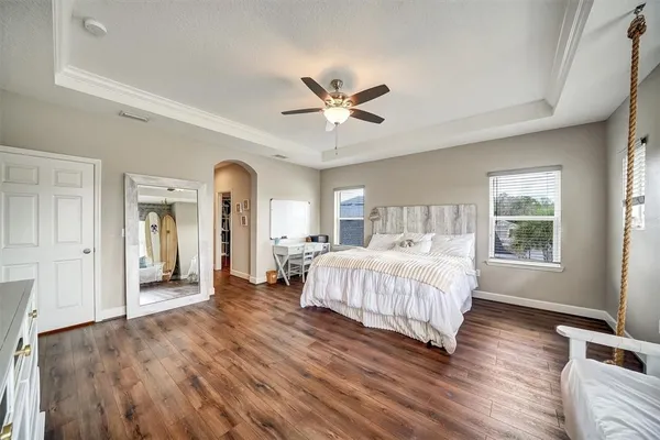 a bedroom with a bed chandelier and a window