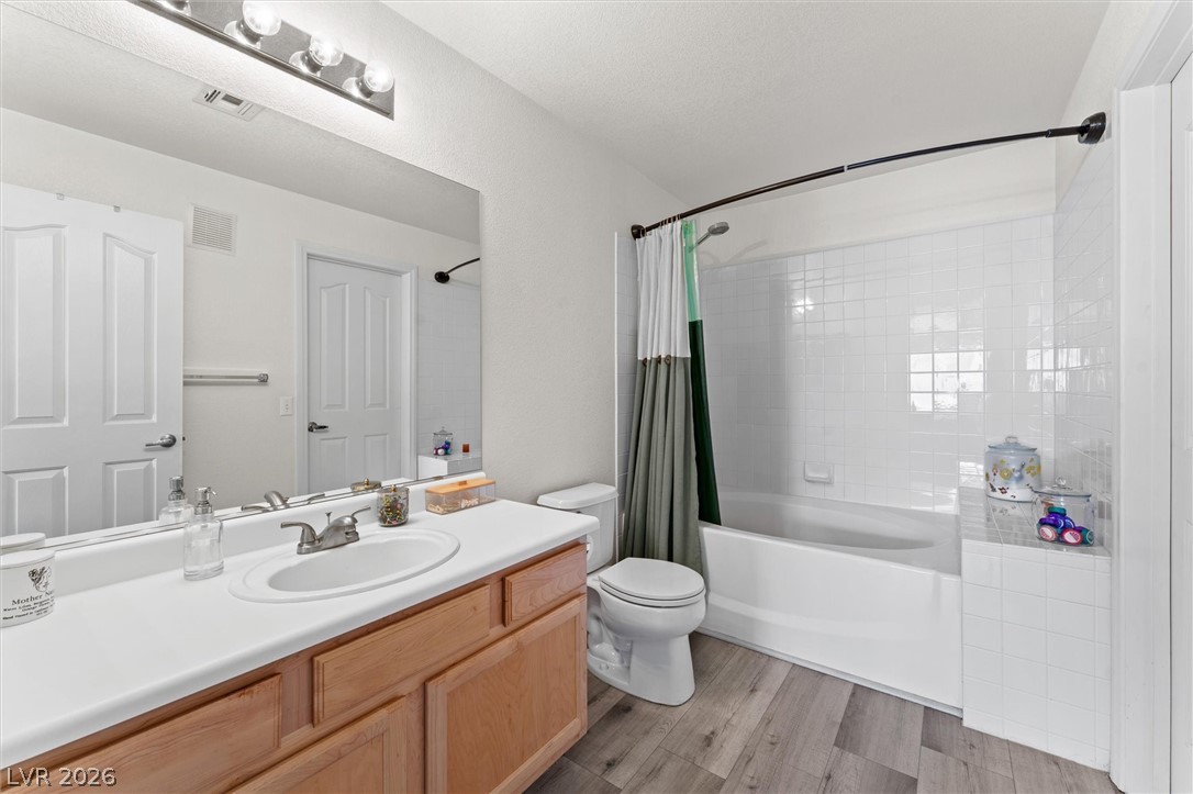 503 Rafkin Place Henderson, NV 89052 - Photo 16 of 18 A pristine bathroom features a single vanity, a standard tub-shower combination, and durable wood-look flooring.