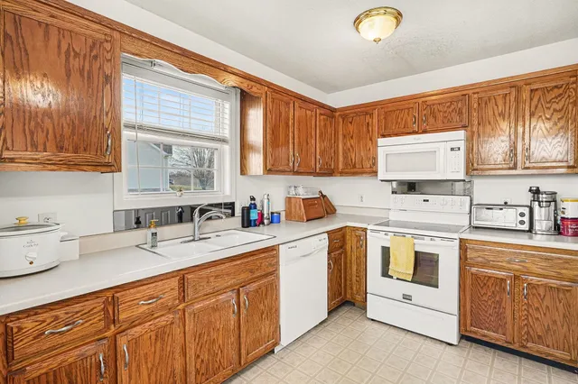 a kitchen with granite countertop a sink stainless steel appliances and cabinets