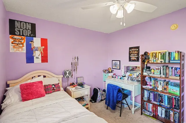a bedroom with a bed and a bookshelf in it