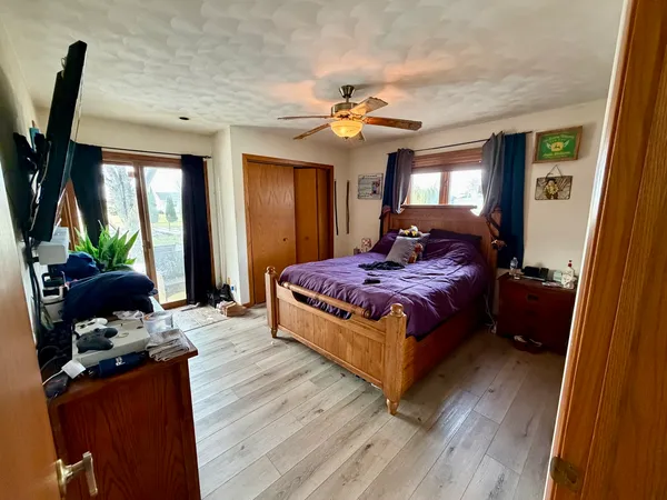 a bedroom with a bed flat screen tv and a large window