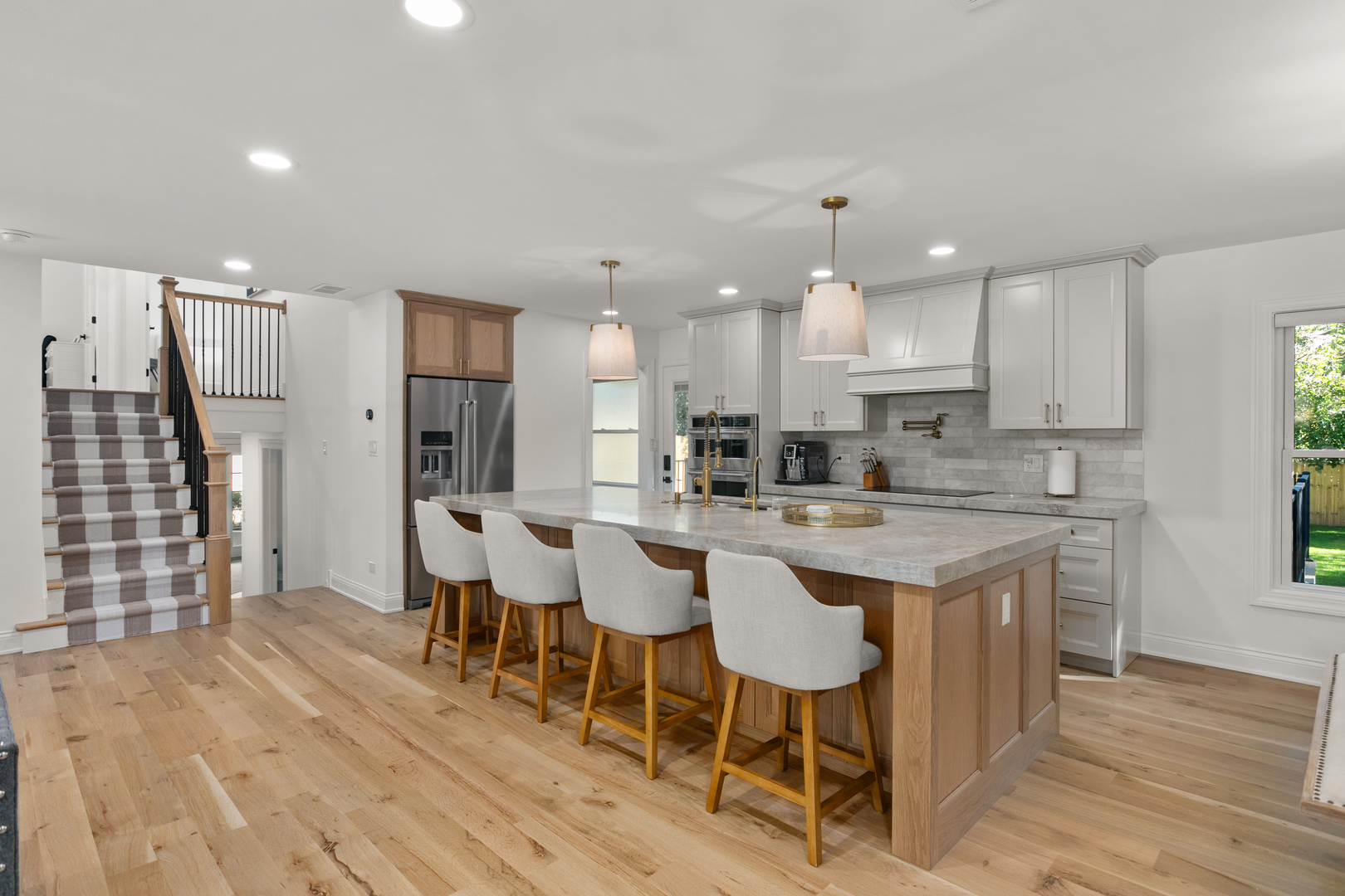 1349 Tinker Way Glenview, IL 60025 - Photo 6 of 42 a kitchen with stainless steel appliances kitchen island granite countertop a wooden floor and white cabinets