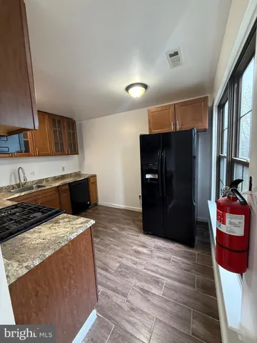 a kitchen with stainless steel appliances kitchen island granite countertop a refrigerator stove and oven