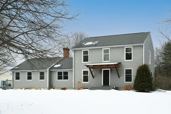 a front view of a house with a yard covered in snow