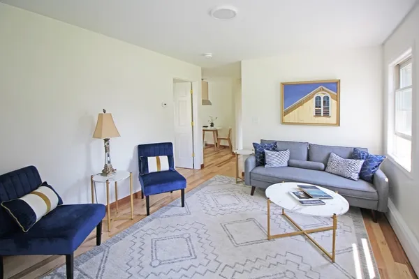 a kitchen with stainless steel appliances granite countertop a sink a stove a dining table and chairs with wooden floor