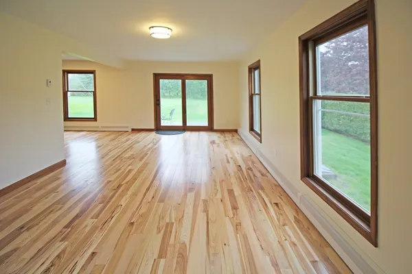 a view of a room with wooden floor and windows