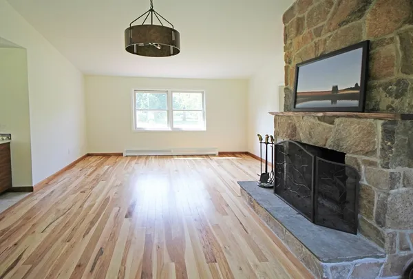 a living room with a wooden floor and a fireplace
