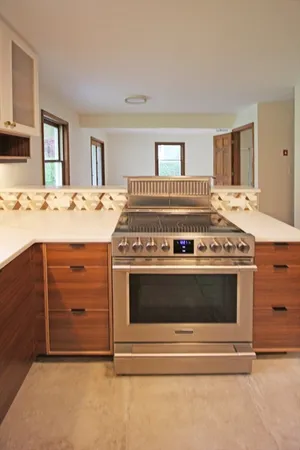 a stove top oven sitting inside of a kitchen