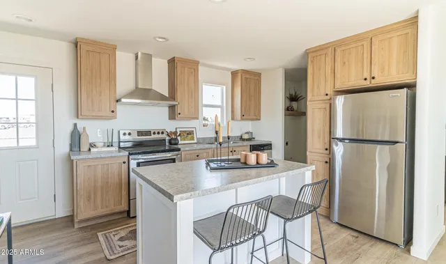 a kitchen with a refrigerator a stove a sink and white cabinets with wooden floor