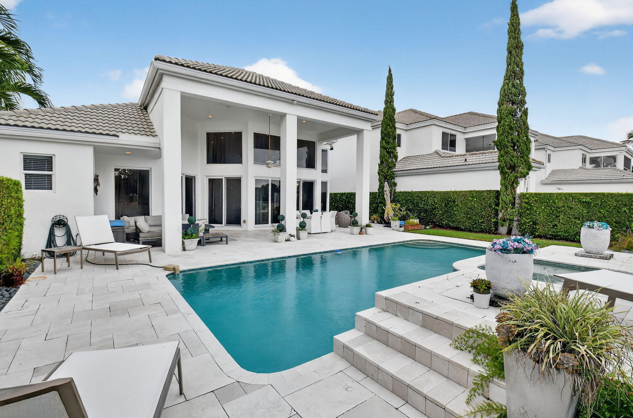 2563 Northwest 63rd Street Boca Raton, FL 33496 - Photo 47 of 65 a view of a patio with couches table and chairs under an umbrella