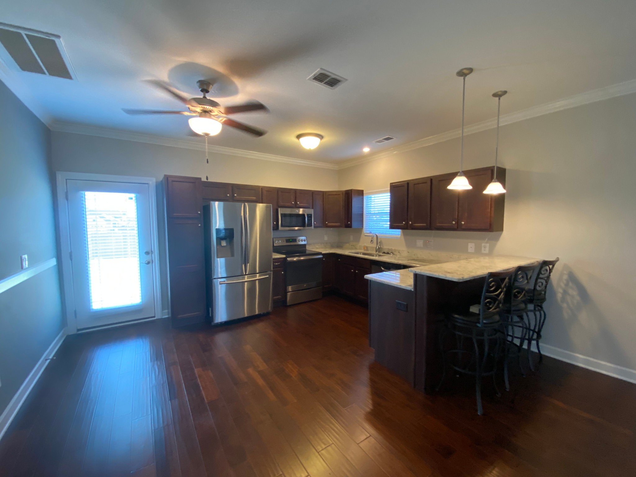 4813 Compassion Lane Murfreesboro, TN 37128 - Photo 4 of 17 a open kitchen with stainless steel appliances granite countertop a refrigerator a stove a sink dishwasher a dining table and chairs with wooden floor