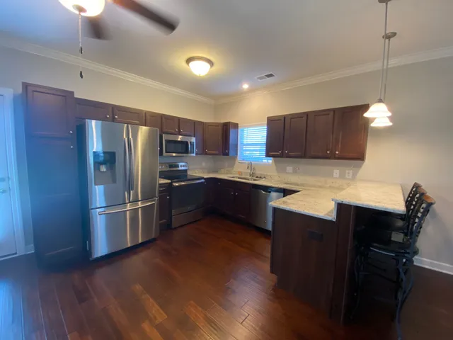 a kitchen with kitchen island a counter space a sink appliances and cabinets
