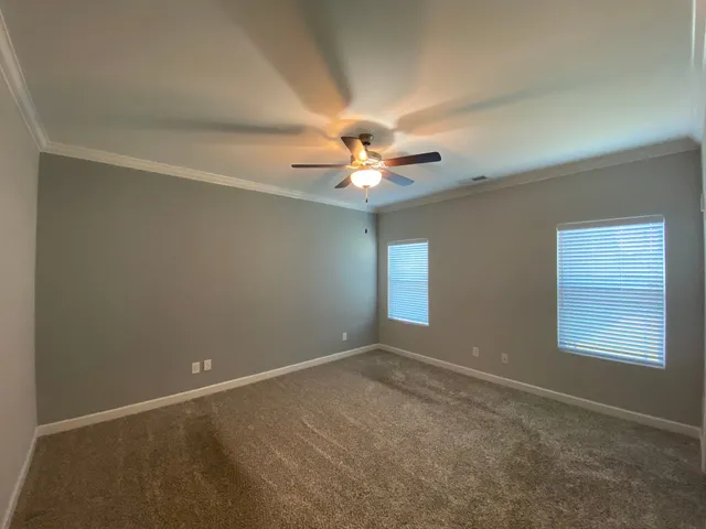 an empty room with a window and a ceiling fan