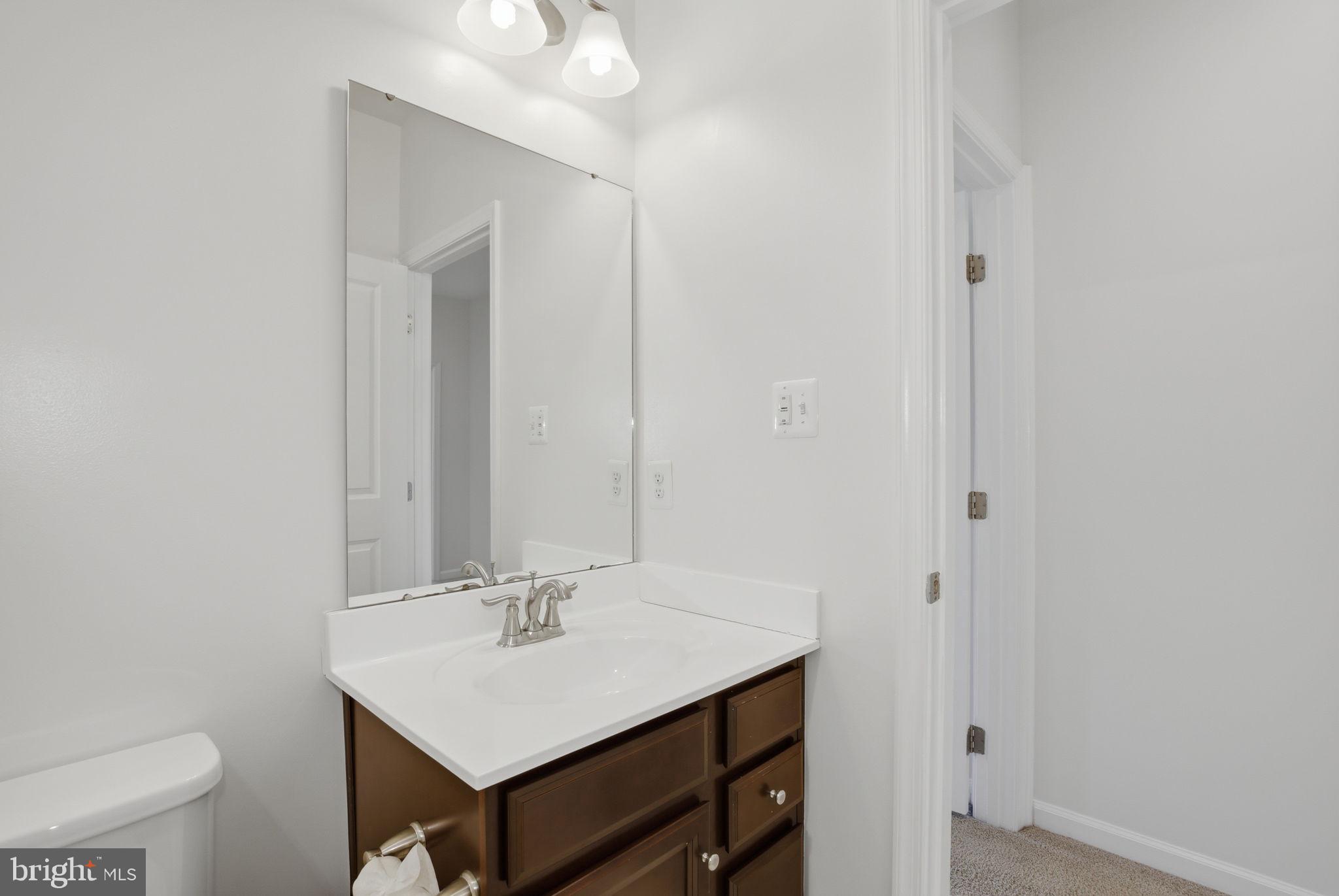 2784 Fredericksburg Road Hanover, MD 21076 - Photo 46 of 60 a bathroom with a sink a toilet and a mirror