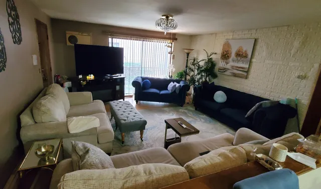 a living room with furniture a window and a flat screen tv