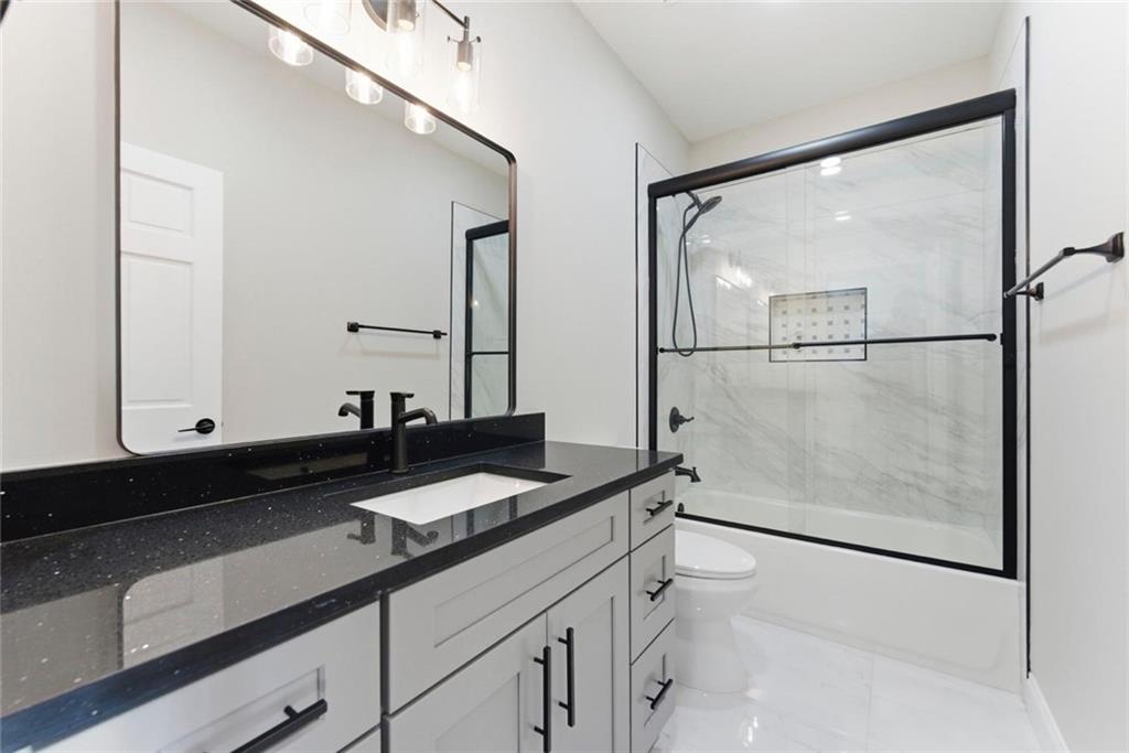 2990 Shallowford Road Atlanta, GA 30341 - Photo 27 of 34 a bathroom with a granite countertop sink a mirror and a shower
