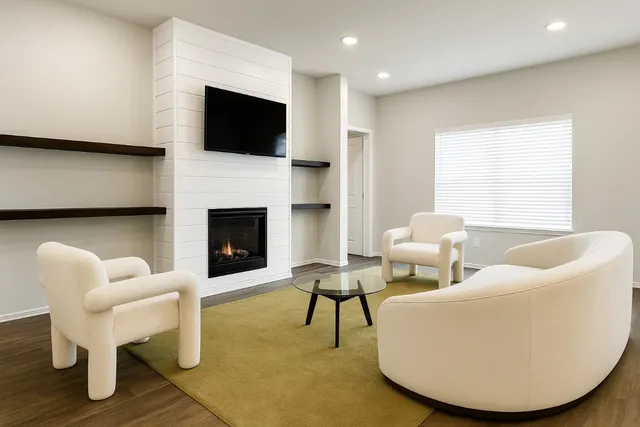 a living room with furniture a fireplace and a flat screen tv