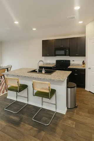 a kitchen with stainless steel appliances kitchen island granite countertop a sink and a stove
