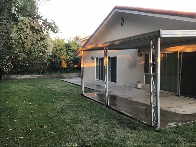 a backyard of a house with table and chairs
