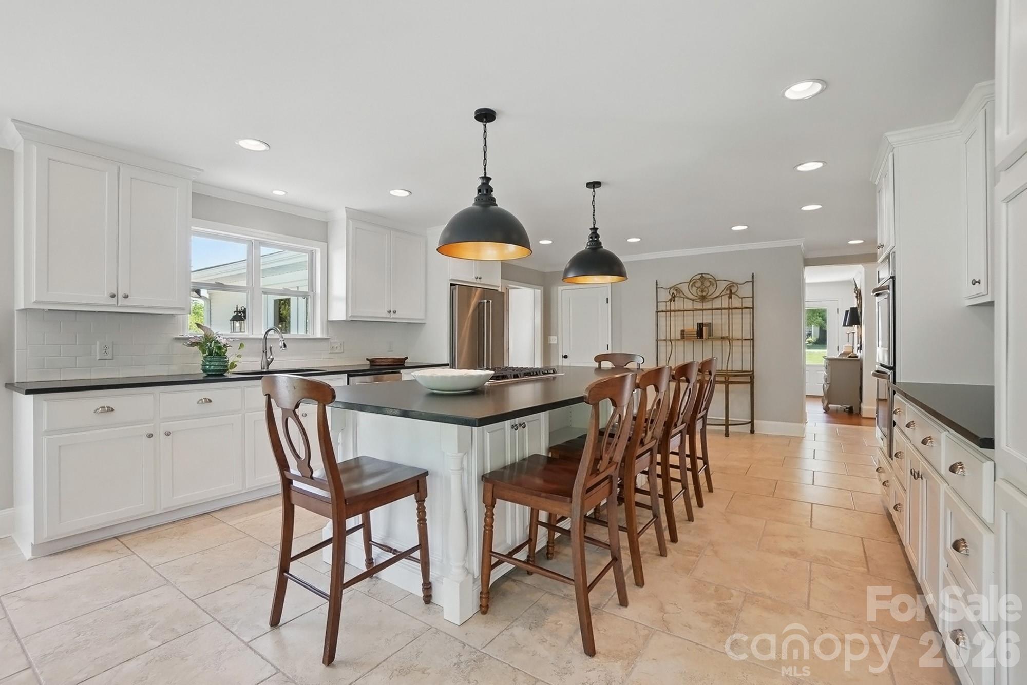 411 Baucom Deese Road Monroe, NC 28110 - Photo 13 of 45 a kitchen with stainless steel appliances kitchen island granite countertop a table chairs sink and cabinets