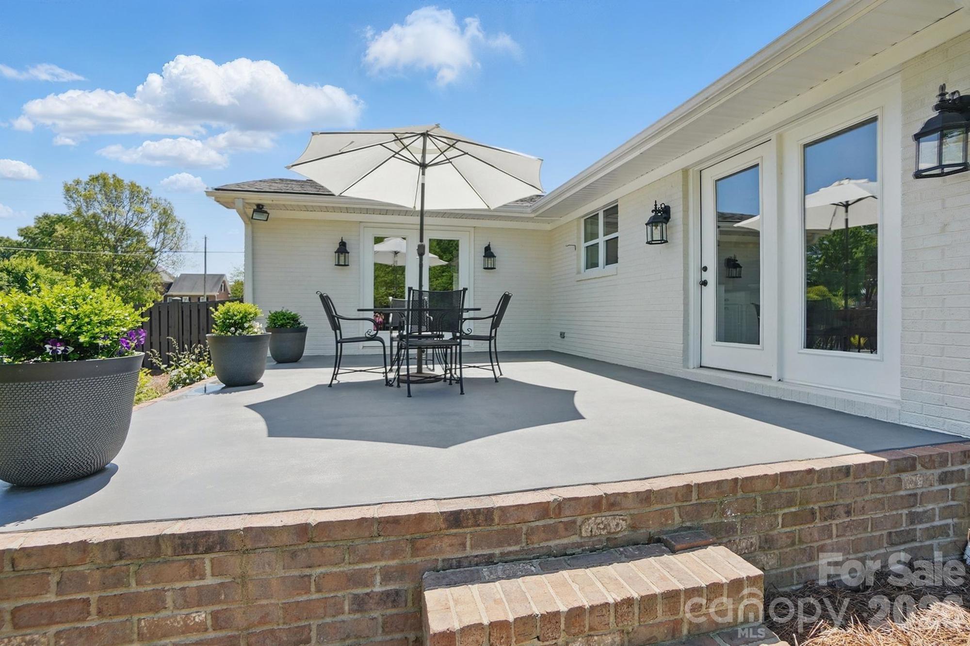 411 Baucom Deese Road Monroe, NC 28110 - Photo 43 of 45 a view of a patio with table and chairs under an umbrella