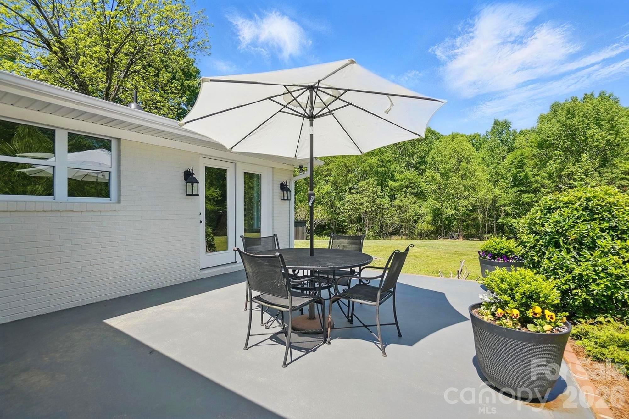 411 Baucom Deese Road Monroe, NC 28110 - Photo 44 of 45 a patio with a table and chairs under an umbrella