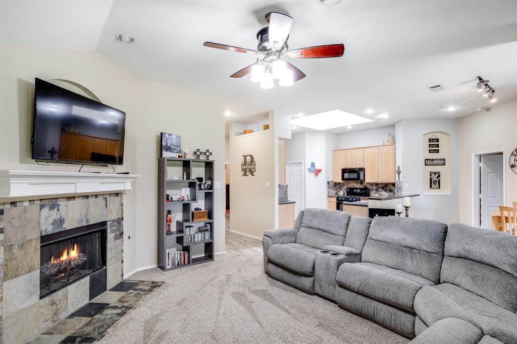 6403 Highland Crest Lane Sachse, TX 75048 - Photo 8 of 40 Living area featuring light carpet, a ceiling fan, a skylight, a tile fireplace, and recessed lighting